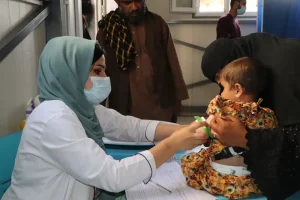 Zarghona, asistente de enfermería de MSF, mide la circunferencia del brazo (MUAC) de un niño en la sala de triaje del pabellón pediátrico del Hospital Regional de Mazar-i-Sharif.