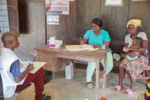 Sesión de tutoría clínica de la Academia de Atención Sanitaria de MSF con el mentor Stephen durante una consulta de atención ambulatoria en el Centro de Salud Comunitario de Kpandebu en Sierra Leona.