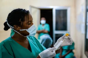 Oumou Bah, supervisora ​​de enfermería de MSF, extrae de un vial de antitoxina diftérica (DAT) mientras el personal prepara a un paciente para recibir la antitoxina en el Centro de Tratamiento Epidemiológico de Siguiri, Guinea.