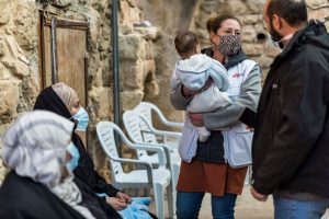 Una integrante de MSF cargando a un bebé en Hebron