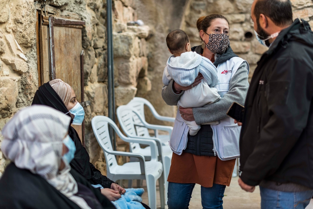 Una integrante de MSF cargando a un bebé en Hebron