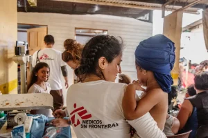 Personal de MSF sostiene a una niña en el punto de atención de MSF en Panamá.