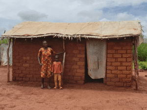 Chancela Tchaga está con su hijo Ezéchiel, frente a su casa reconstruida en RCA