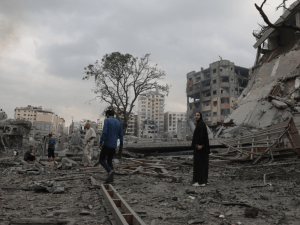 Guerra en Gaza: Personas se encuentran en medio de un edificio destruido después de un ataque aéreo en Gaza.