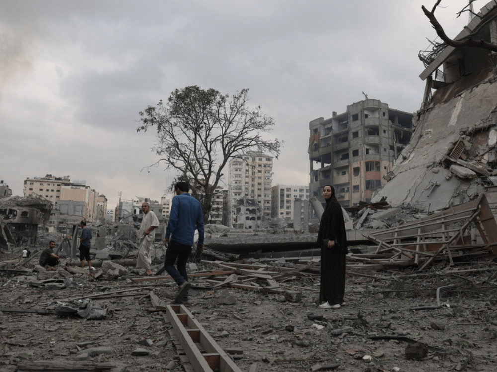 Guerra en Gaza: Personas se encuentran en medio de un edificio destruido después de un ataque aéreo en Gaza.