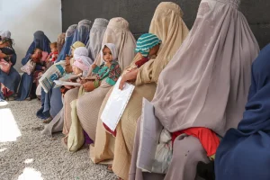 Mujeres sentadas en la sala de espera fuera del Centro de Alimentación Terapéutica Ambulatoria de MSF donde atendemos a niños y niñas con desnutrición. Kandahar, Afganistán.