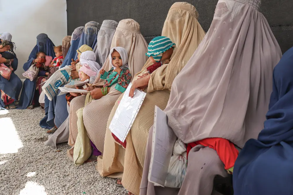 Mujeres sentadas en la sala de espera fuera del Centro de Alimentación Terapéutica Ambulatoria de MSF donde atendemos a niños y niñas con desnutrición. Kandahar, Afganistán.