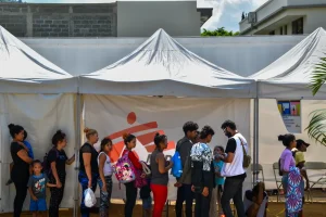 Personas migrantes hacen una fila para acceder a atención médica o acompañamiento psicológico en la clínica móvil de MSF en Danlí.