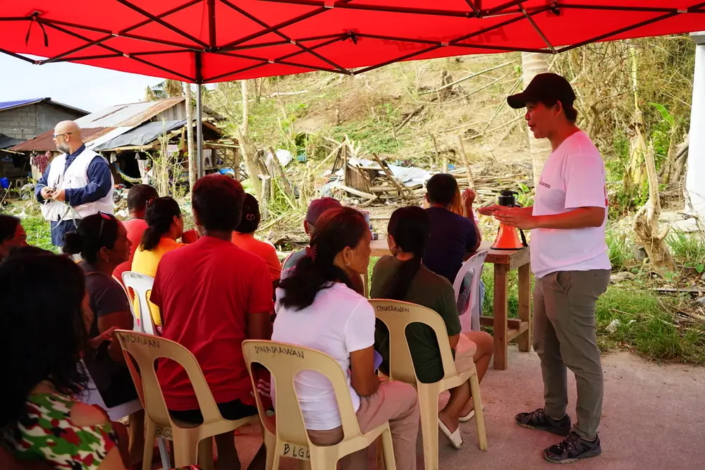 Sarah Jane Deocampo, responsable de salud mental, realiza una sesión de psicoeducación mientras los pacientes esperan su turno en la clínica móvil. Filipinas, 2024.