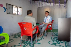 Mohammad, consejero de salud mental de MSF en el noroeste de Siria, lleva a cabo una sesión de salud mental con un paciente que experimenta problemas psicológicos en una de las clínicas móviles de MSF en los campamentos de Dair Hassan.