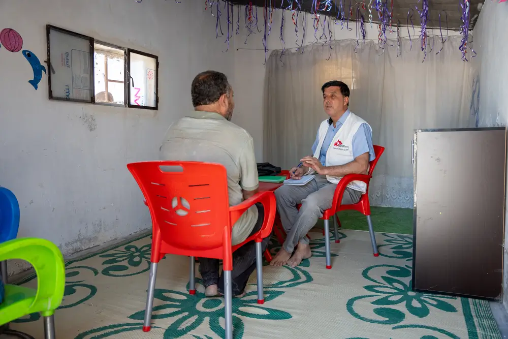 Mohammad, consejero de salud mental de MSF en el noroeste de Siria, lleva a cabo una sesión de salud mental con un paciente que experimenta problemas psicológicos en una de las clínicas móviles de MSF en los campamentos de Dair Hassan.