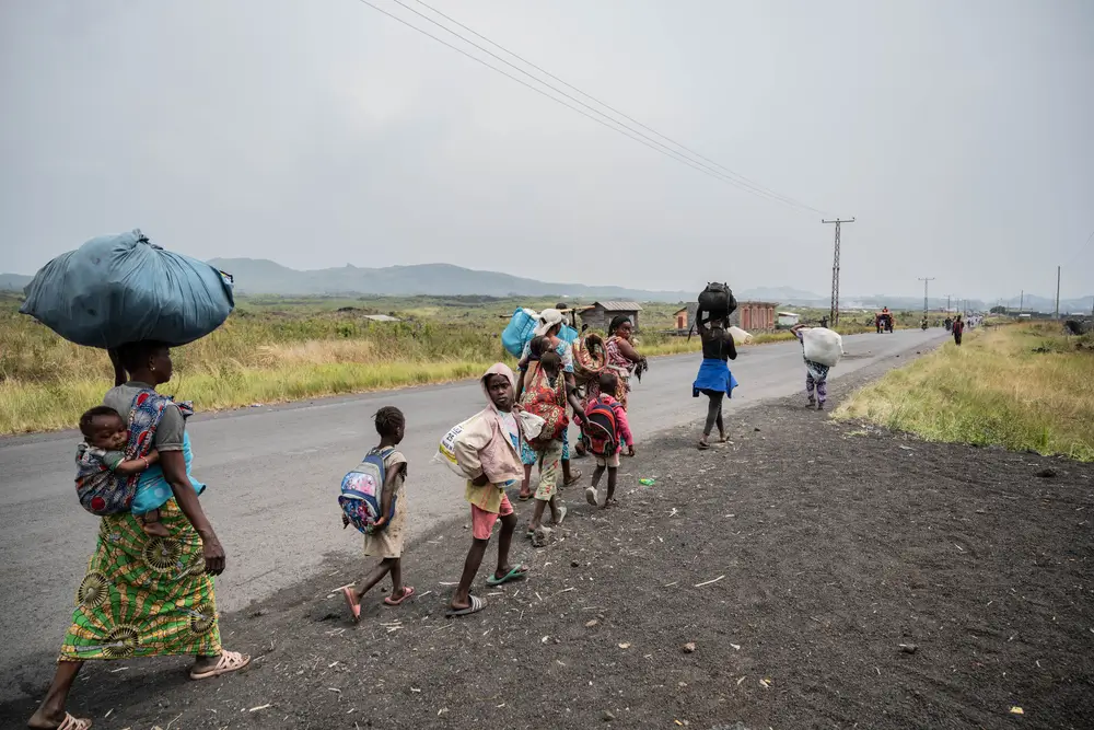 Las personas que viven en campamentos de desplazados, como el de Nzulo, huyen a Goma mientras se desarrollan combates a unos kilómetros de distancia. Provincia de Kivu del Norte, República Democrática del Congo, enero de 2025.