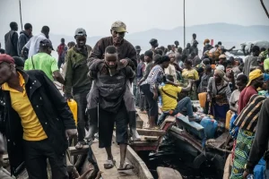 Un hombre es rescatado de un barco que llegó al puerto de Kituku, en Goma, y ​​que transportaba a personas que huían de los combates que se están librando en Kivu del Norte y Kivu del Sur. Provincia de Kivu del Norte, República Democrática del Congo, enero de 2025.