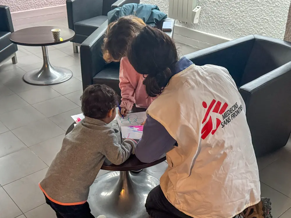 Dos niños iraníes con su madre en Calais. MSF les dio cobijo. Aquí juegan con una trabajadora de MSF. © Mohammad Ghannam / MSF