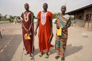 Tres mujeres llevan sus registros de vacunación después de haber recibido su primera dosis de la vacuna contra la hepatitis E en diciembre de 2023 en Hai Matar, estado de Jonglei.
