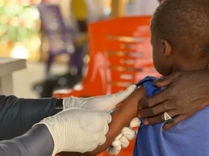 Un niño es vacunado por un miembro del personal de MSF en el campo de tránsito de Adré, en el este de Chad. Enfermedades como el sarampión pueden propagarse rápidamente cuando las personas no vacunadas viven en condiciones de hacinamiento y hacinamiento, como en campos de desplazados y refugiados.