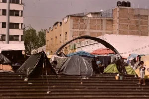 Personas migrantes del continente americano y extracontinentales han construido un refugio temporal en a Plaza de la Soledad en Ciudad de México.