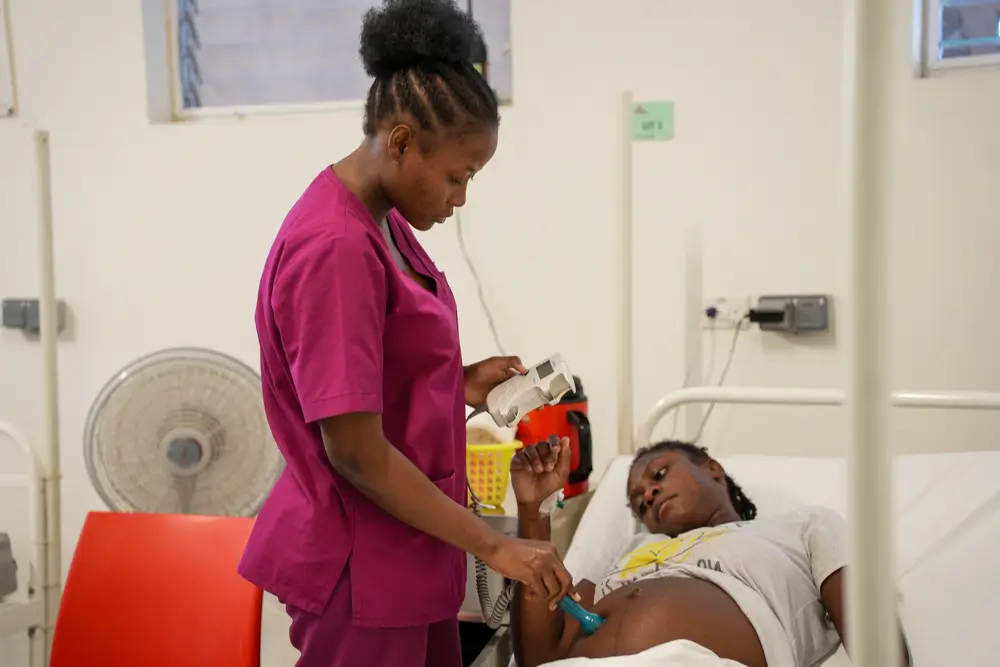 Una enfermera revisa el latido del corazón de un bebé de una mujer de 21 años que está embarazada de siete meses.