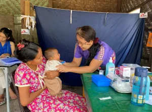 Una integrante de MSF revisando a un bebé en una clínica movil de la organización en Mandalay, donde respondió tras el terremoto en Myanmar.