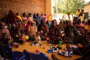 Mujeres, niñas y niños asisten a las sesiones sobre la promoción de la salud nutricional en el centro de alimentación para pacientes hospitalizados de la ciudad de Katsina, Nigeria.