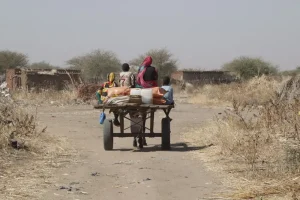 Una familia regresa a casa tras recibir canastas de alimentos en una distribución en Darfur Sur. Sudán, enero de 2025.