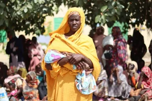 Ikhlas Musa Ramadan, una de las muchas madres admitidas en el programa de MSF para cuidar a mujeres lactantes y embarazadas que sufren de desnutrición severa, hace fila esperando su turno para recibir la cesta de alimentos.