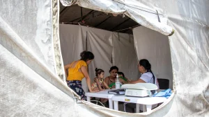 Mariocy (en el centro de la foto), venezolana de 39 años, asistió a consulta con su hija y sus dos nietos. Recibió atención en salud física para sus dos nietos y en salud mental para ella y su hija.