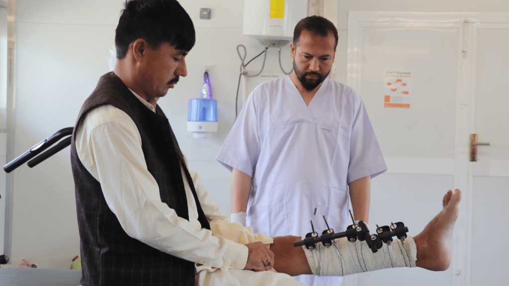 Un fisioterapeuta de MSF en el Centro de Trauma de Afganistán atendiendo a su paciente con traumatismo.