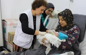 Rita Botelho, comadrona, conversa con una madre mientras examina a su recién nacido. Hospital Emirati, en Rafah, sur de Gaza, 15 de enero de 2024.