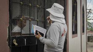 David, promotor de salud de MSF, conversa con una vecina de la comunidad para informarle sobre la liberación de mosquitos con Wolbachia que MSF planea realizar en esta zona de Tegucigalpa.