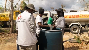 Lal Badshah, responsable de agua y saneamiento supervisa el llenado de un tanque de agua de 200 litros en la parroquia de Santa Isabel. La parroquia aún carece de electricidad y la infraestructura hídrica sigue interrumpida.