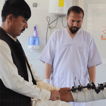 Un fisioterapeuta de MSF en el Centro de Trauma de Afganistán atendiendo a su paciente con traumatismo.