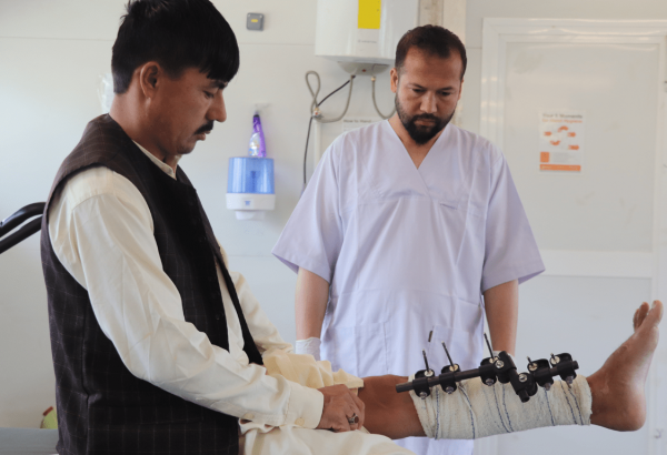 Un fisioterapeuta de MSF en el Centro de Trauma de Afganistán atendiendo a su paciente con traumatismo.