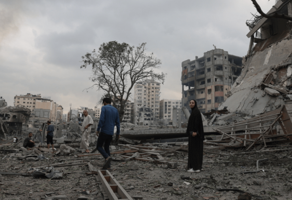 Guerra en Gaza: Personas se encuentran en medio de un edificio destruido después de un ataque aéreo en Gaza.