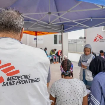 Un trabajador de MSF en la sala de espera frente a la clínica móvil del Centro de Acceso Cerrado en Zervou, Samos.