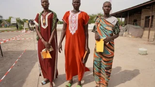 Tres mujeres llevan sus registros de vacunación después de haber recibido su primera dosis de la vacuna contra la hepatitis E en diciembre de 2023 en Hai Matar, estado de Jonglei.