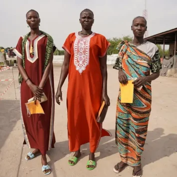 Tres mujeres llevan sus registros de vacunación después de haber recibido su primera dosis de la vacuna contra la hepatitis E en diciembre de 2023 en Hai Matar, estado de Jonglei.