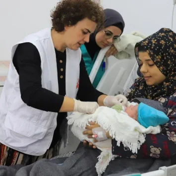 Rita Botelho, comadrona, conversa con una madre mientras examina a su recién nacido. Hospital Emirati, en Rafah, sur de Gaza, 15 de enero de 2024.
