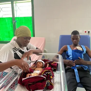 Una pareja está practicando el método Kangourou para ayudar a sus gemelos recién nacidos prematuros a sobrevivir. Burkina Faso.