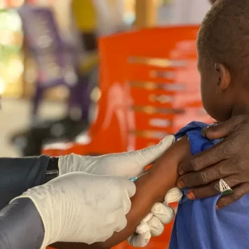 Un niño es vacunado por un miembro del personal de MSF en el campo de tránsito de Adré, en el este de Chad. Enfermedades como el sarampión pueden propagarse rápidamente cuando las personas no vacunadas viven en condiciones de hacinamiento y hacinamiento, como en campos de desplazados y refugiados.