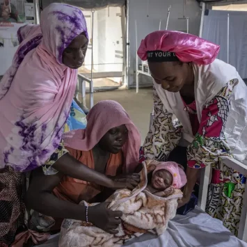 Personal de Médicos Sin Fronteras enla sala de maternidad del hospital de Metche con un bebé reciénnacido y su madre.