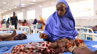 Asma'u se sienta junto a su hija, Shamsiya, quien ha sido ingresada en el centro de alimentación terapéutica para pacientes hospitalizados Kofar Suari por desnutrición, en el estado de Katsina, Nigeria, en octubre de 2024.