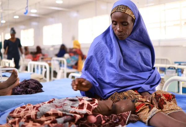 Asma'u se sienta junto a su hija, Shamsiya, quien ha sido ingresada en el centro de alimentación terapéutica para pacientes hospitalizados Kofar Suari por desnutrición, en el estado de Katsina, Nigeria, en octubre de 2024.