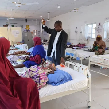 Un enfermero de MSF se prepara para tomar los signos vitales de un niño en cuidados intensivos de Ungwa Uku, en donde MSF trata la desnutrición infantil en Kano, Nigeria.