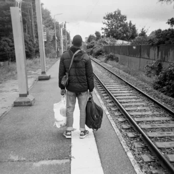 Un joven exiliado en la estación de tren de Calais