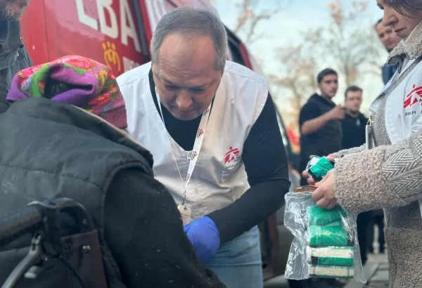 El médico de MSF Oleksandr Hontariev realiza un tratamiento quirúrgico inicial en el brazo de un paciente. Cerca del centro de tránsito, donde tenemos nuestra clínica móvil