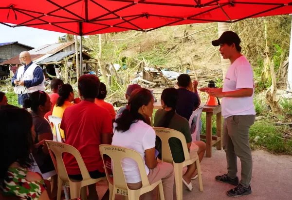 Sarah Jane Deocampo, responsable de salud mental, realiza una sesión de psicoeducación mientras los pacientes esperan su turno en la clínica móvil. Filipinas, 2024.