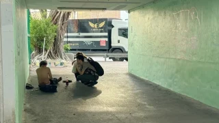 Un miembro del personal de MSF atiende a una persona sin hogar en un paso subterráneo sombreado en Hong Kong. Diciembre de 2024.