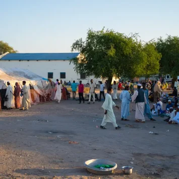 Fuera de la unidad de cuidados pre y posoperatorios del hospital del condado de Renk, los cuidadores esperan para visitar a sus seres queridos. Sudán del Sur, 19 de diciembre de 2024.