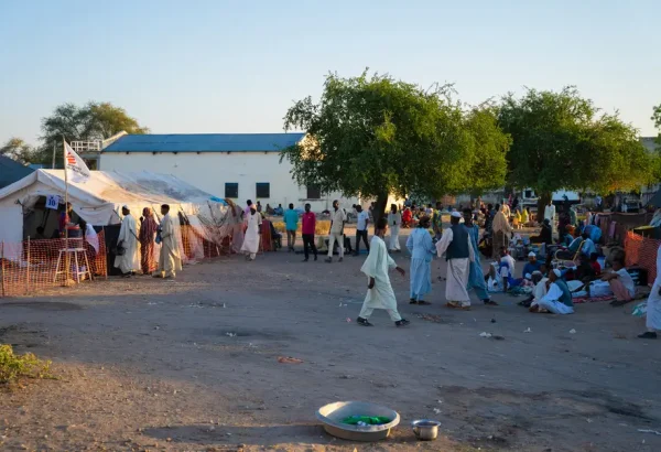 Fuera de la unidad de cuidados pre y posoperatorios del hospital del condado de Renk, los cuidadores esperan para visitar a sus seres queridos. Sudán del Sur, 19 de diciembre de 2024.